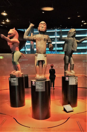 Drei Skulpturen im Musée du quai Branly aus dem ehemaligen Königspalast in Dahomey, mit Hinweistafeln auf ihre künftige Restitution im Oktober 2021.